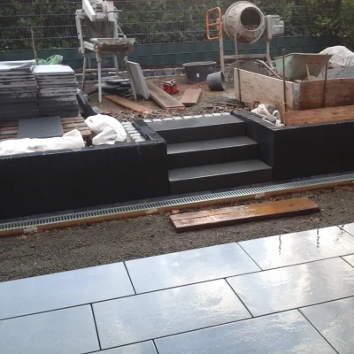 Verlegung von Keramikplatten in Blaustein-Optik vor der neuen Garten-Empore.