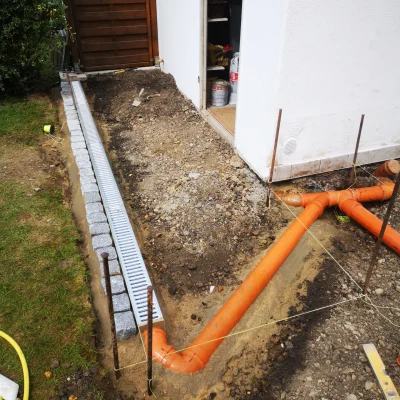 Laufende Pflasterarbeiten und Installation der Entwässerung für ein langlebiges Ergebnis.