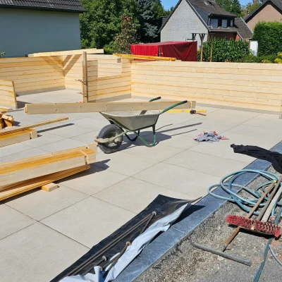 Präzises Setzen der ersten Randplatten im Außenbereich während der Bauphase durch Markus Lillot.