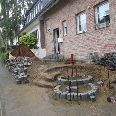 Erste gesetzte Natursteinstufen der neuen Rundtreppe während der Handwerksarbeiten von Markus Lillot.