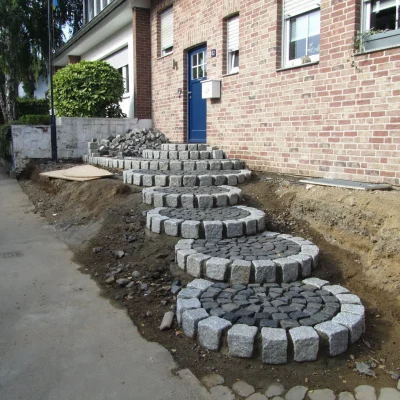 Fertig gesetzte Stufen der Rundtreppenanlage mit angrenzenden Erdarbeiten durch Markus Lillot.